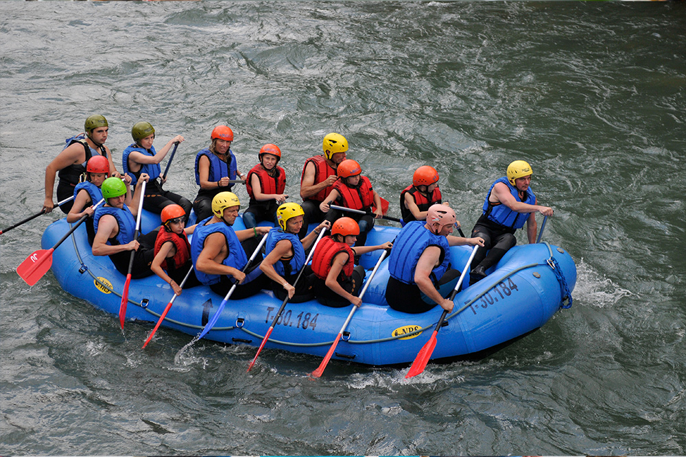Gruppe in einem blauen Raft auf einem Wildfluss