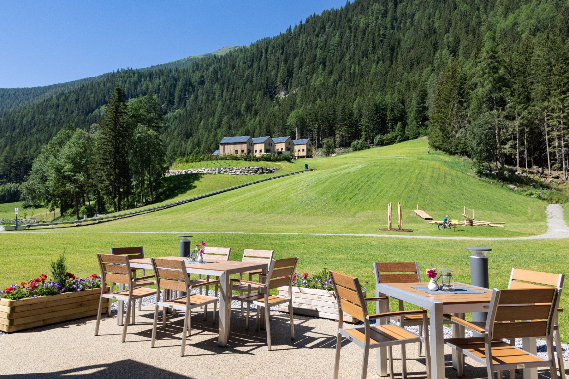 Terrasse mit Blick auf die Chalets und Almwiese